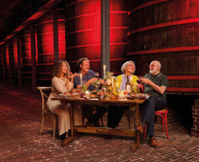 4 mensen rond een tafel tussen de foeders van brouwerij Rodenbach
